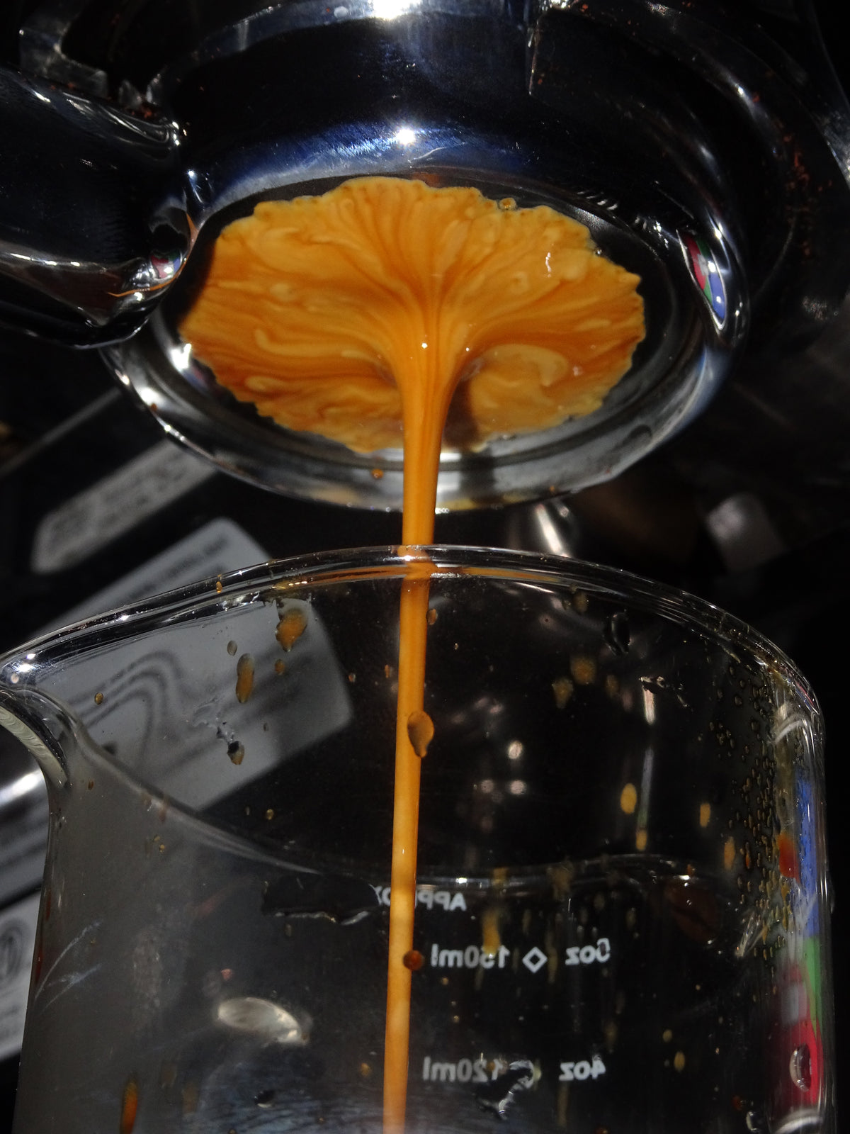 Espresso pouring into a measuring glass